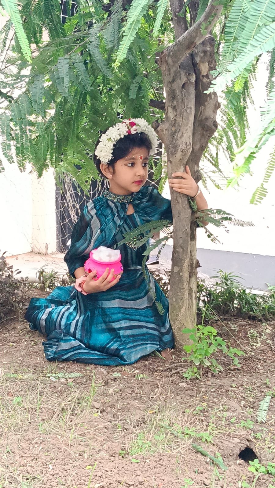 A student holding a decorated pot during the school celebration
